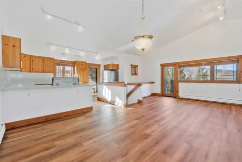 a view of a livingroom with wooden floor and a ceiling fan