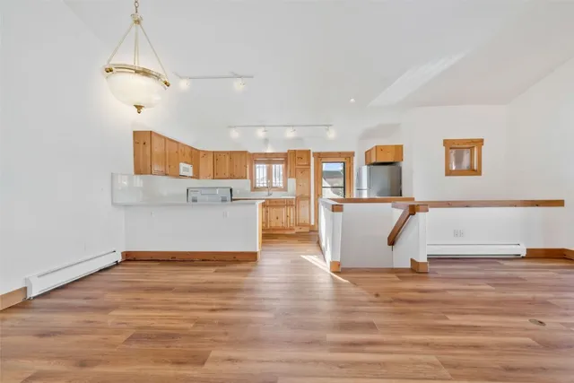 a view of a livingroom with wooden floor and a ceiling fan