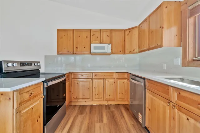 a kitchen with a sink a stove and cabinets