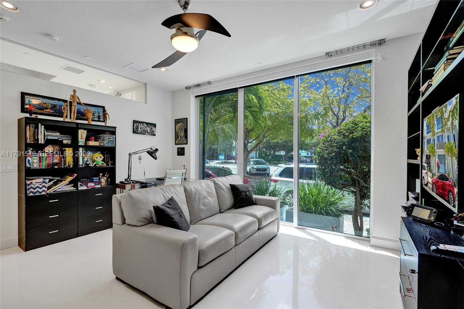 2725 Northeast 1st Street Pompano Beach, FL 33062 - Photo 15 of 59 a living room with furniture a bookshelf and a large window