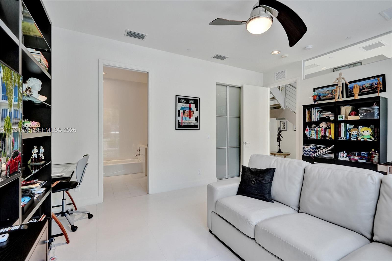 2725 Northeast 1st Street Pompano Beach, FL 33062 - Photo 16 of 59 a living room with furniture and a book shelf
