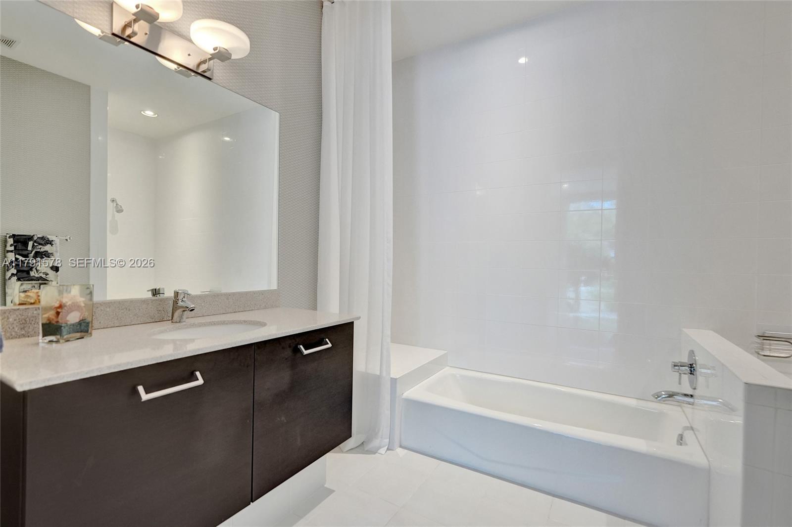 2725 Northeast 1st Street Pompano Beach, FL 33062 - Photo 17 of 59 a bathroom with a tub sink and mirror