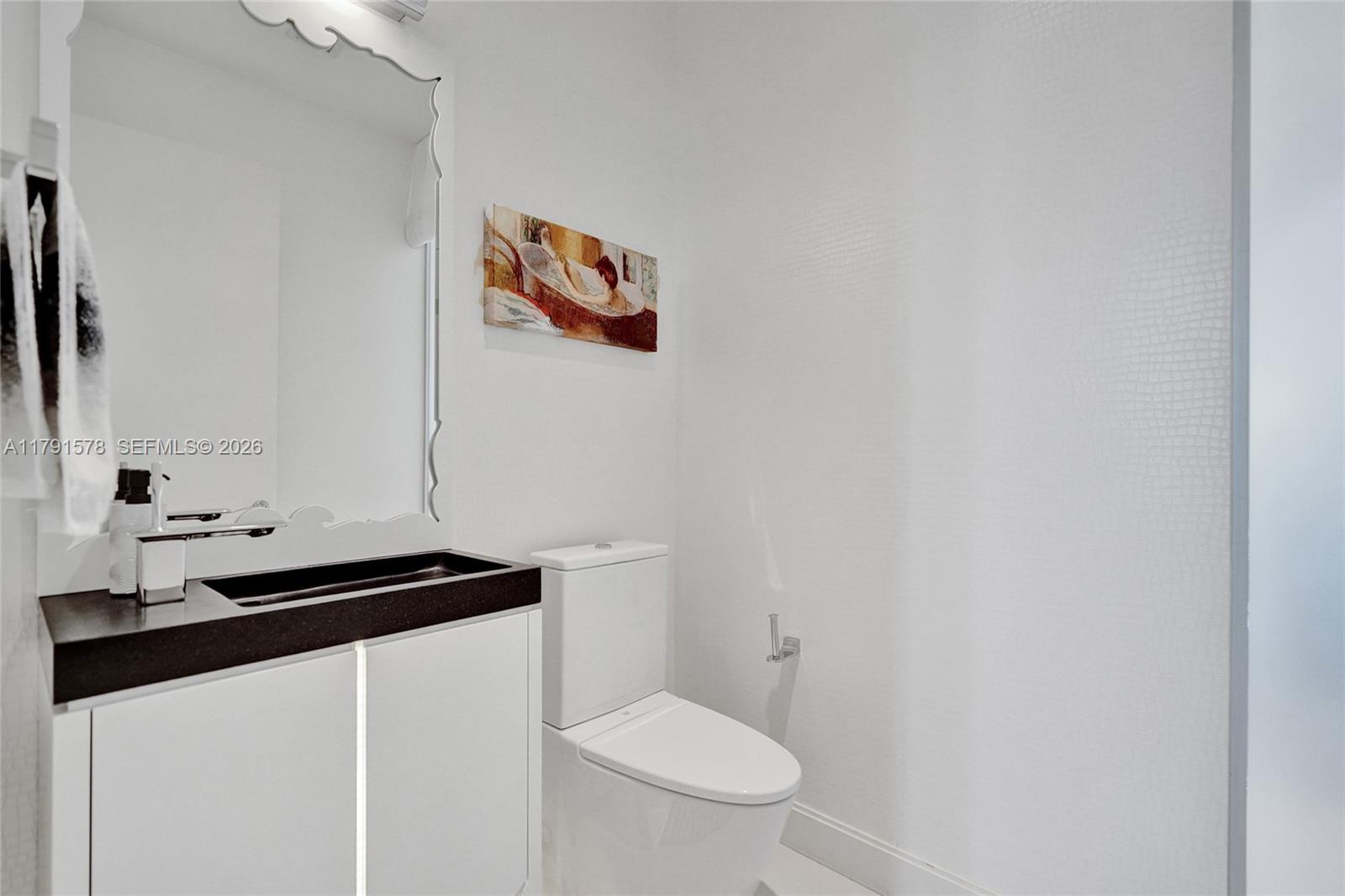 2725 Northeast 1st Street Pompano Beach, FL 33062 - Photo 28 of 59 a bathroom with a sink a toilet and mirror