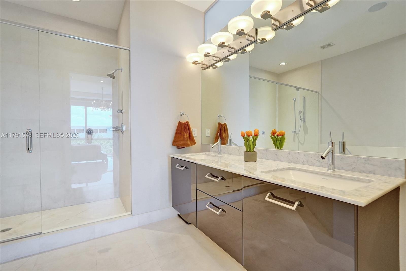 2725 Northeast 1st Street Pompano Beach, FL 33062 - Photo 37 of 59 a bathroom with a granite countertop sink a large mirror and shower