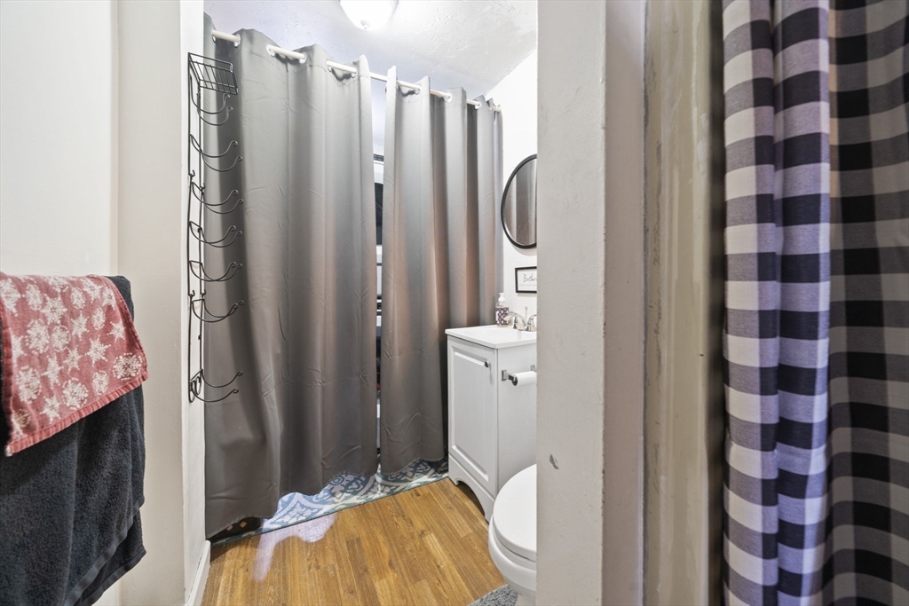 73 Monroe Street Abington, MA 02351 - Photo 12 of 28 a bathroom with a sink a mirror and a shower curtain