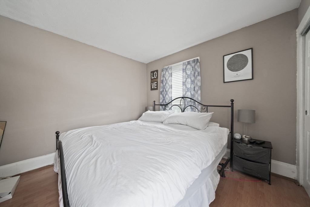 73 Monroe Street Abington, MA 02351 - Photo 21 of 28 a bedroom with a bed and a lamp with window