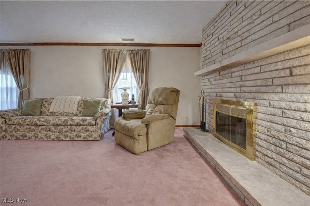14965 Seacrist Road Salem, OH 44460 - Photo 6 of 43 Carpeted living room featuring a brick fireplace and crown molding