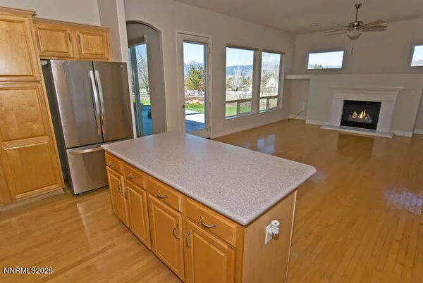 a view of an empty room with wooden floor and windows