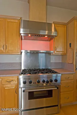 a large kitchen with stainless steel appliances kitchen island a large counter top and a refrigerator