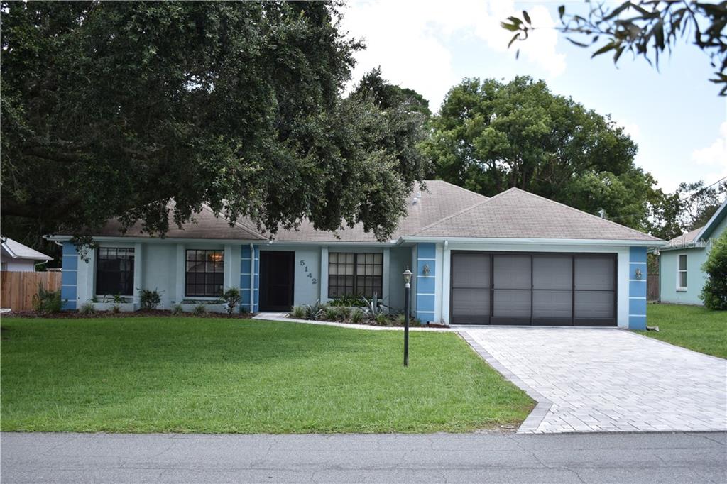 5142 Harbinger Road Spring Hill, FL 34608 - Photo 1 of 1 a house that has a tree in front of it