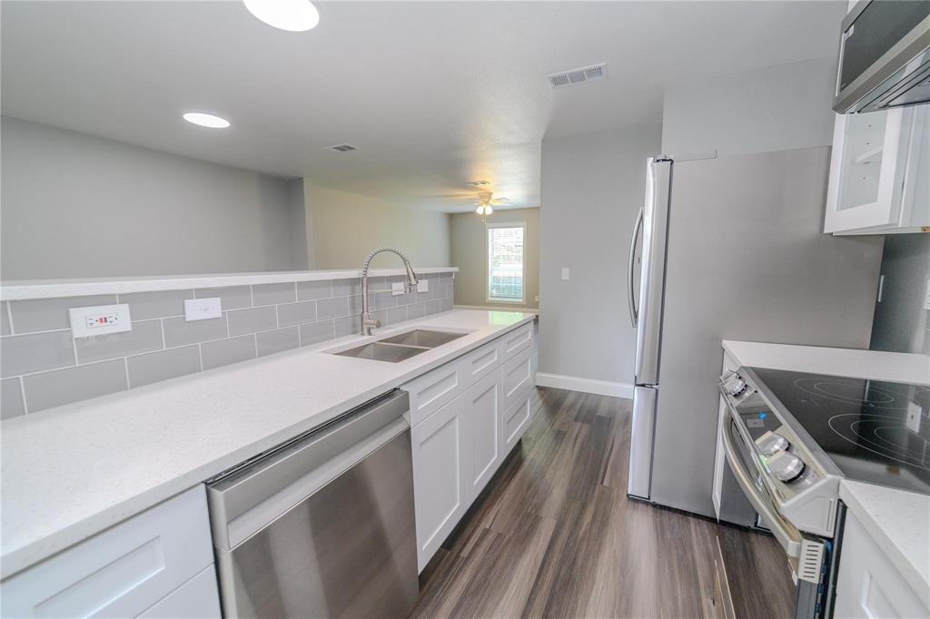 809 Wilcox Street McKinney, TX 75069 - Photo 7 of 26 Kitchen with stainless steel appliances, light stone countertops, white cabinets, dark wood-style flooring, and ceiling fan