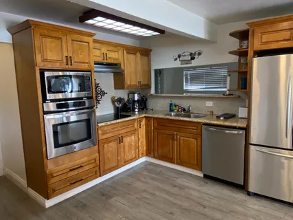 a kitchen with stainless steel appliances granite countertop a stove a sink and a microwave