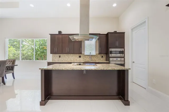 a kitchen with stainless steel appliances granite countertop a stove a sink and a refrigerator