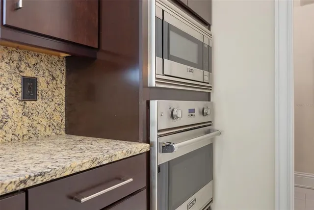 a kitchen with granite countertop cabinets stainless steel appliances and a sink