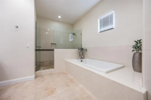 a spacious bathroom with a tub sink and mirror