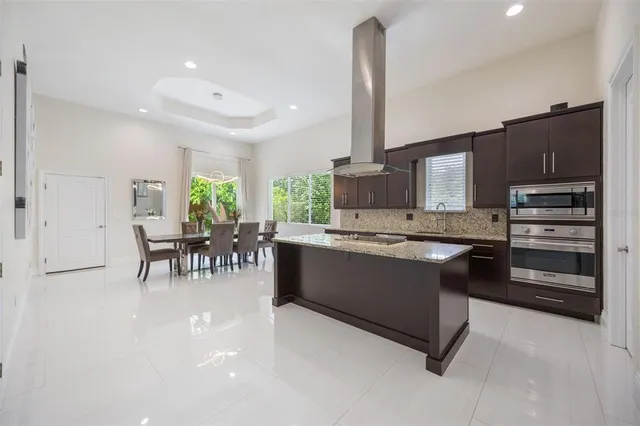 a large kitchen with kitchen island a large counter space appliances and a chandelier
