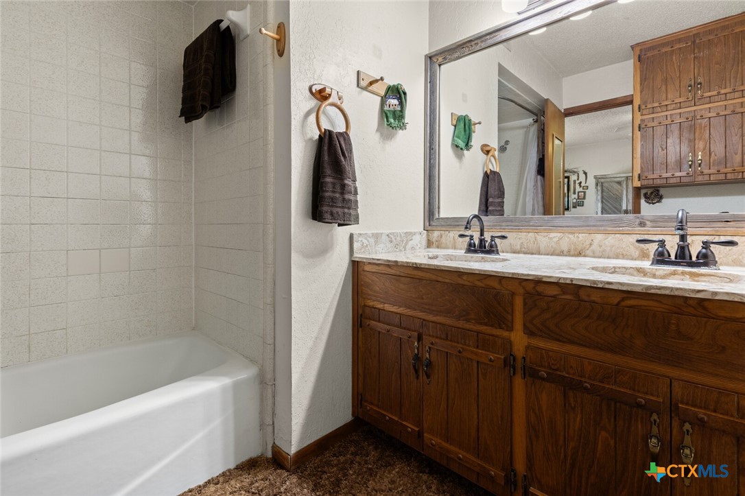 1024 Backstrom Crossing Belton, TX 76513 - Photo 16 of 47 a bathroom with a tub sink and mirror