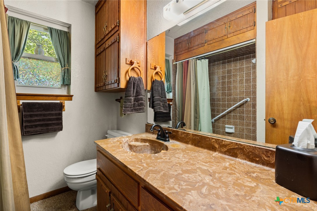 1024 Backstrom Crossing Belton, TX 76513 - Photo 27 of 47 a bathroom with a granite countertop sink toilet and shower
