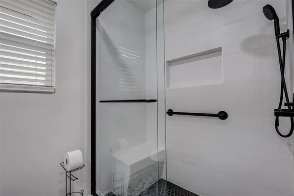 a bathroom with a sink a toilet a mirror and shower