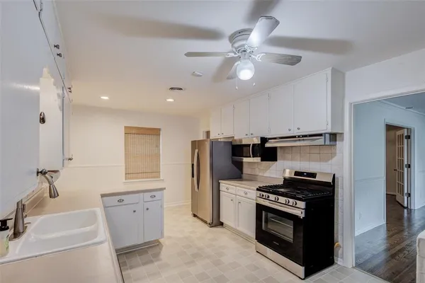 a kitchen with stainless steel appliances a stove a sink and a refrigerator