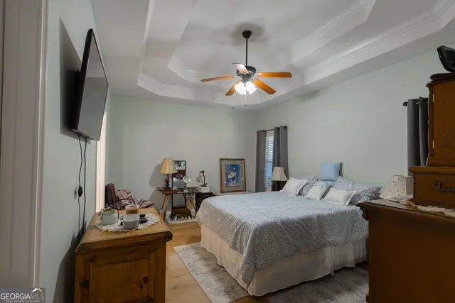 a bedroom with a bed and a flat tv screen on a dresser