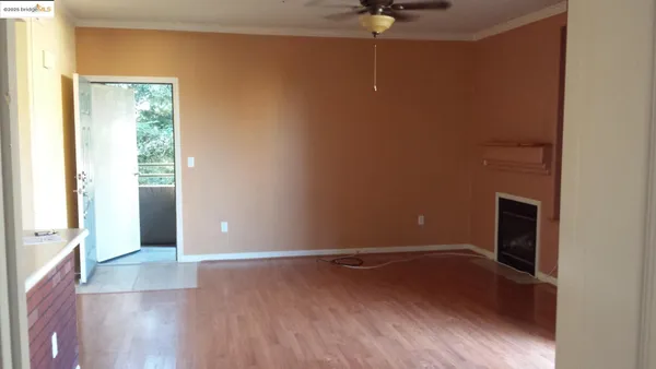 an empty room with wooden floor and chandelier
