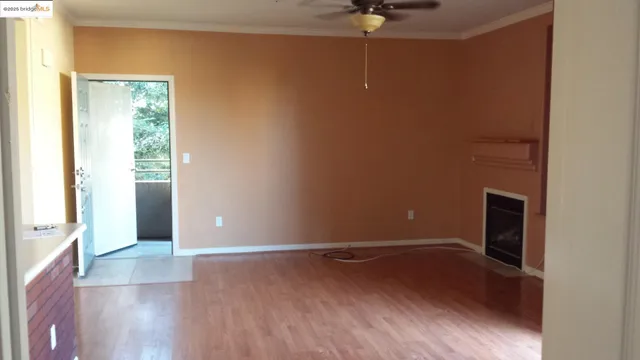 an empty room with wooden floor and chandelier