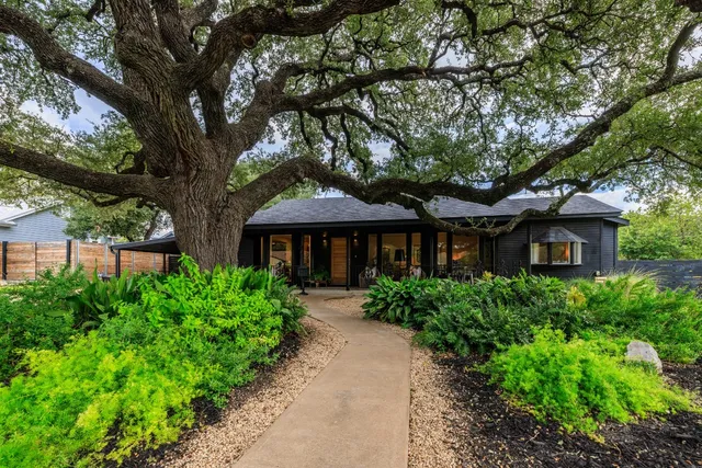 a front view of a house with a yard and potted plants