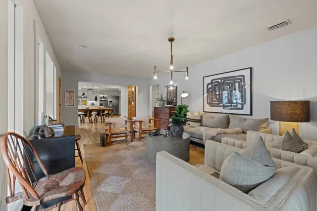 a living room with furniture and a chandelier