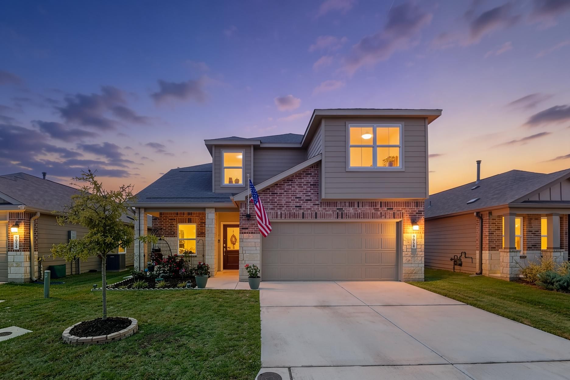 An inviting exterior showcases a blend of brick and siding, complemented by a welcoming driveway.