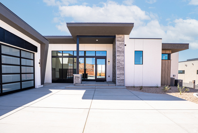 234 Colima Road, Unit 144 Washington, UT 84780 - Photo 2 of 21 Modern architectural design featuring a flat roofline, glass panel garage door, stone accent pillar, recessed entry, and large format windows