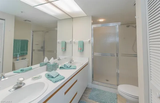 a bathroom with a granite countertop sink a toilet and shower
