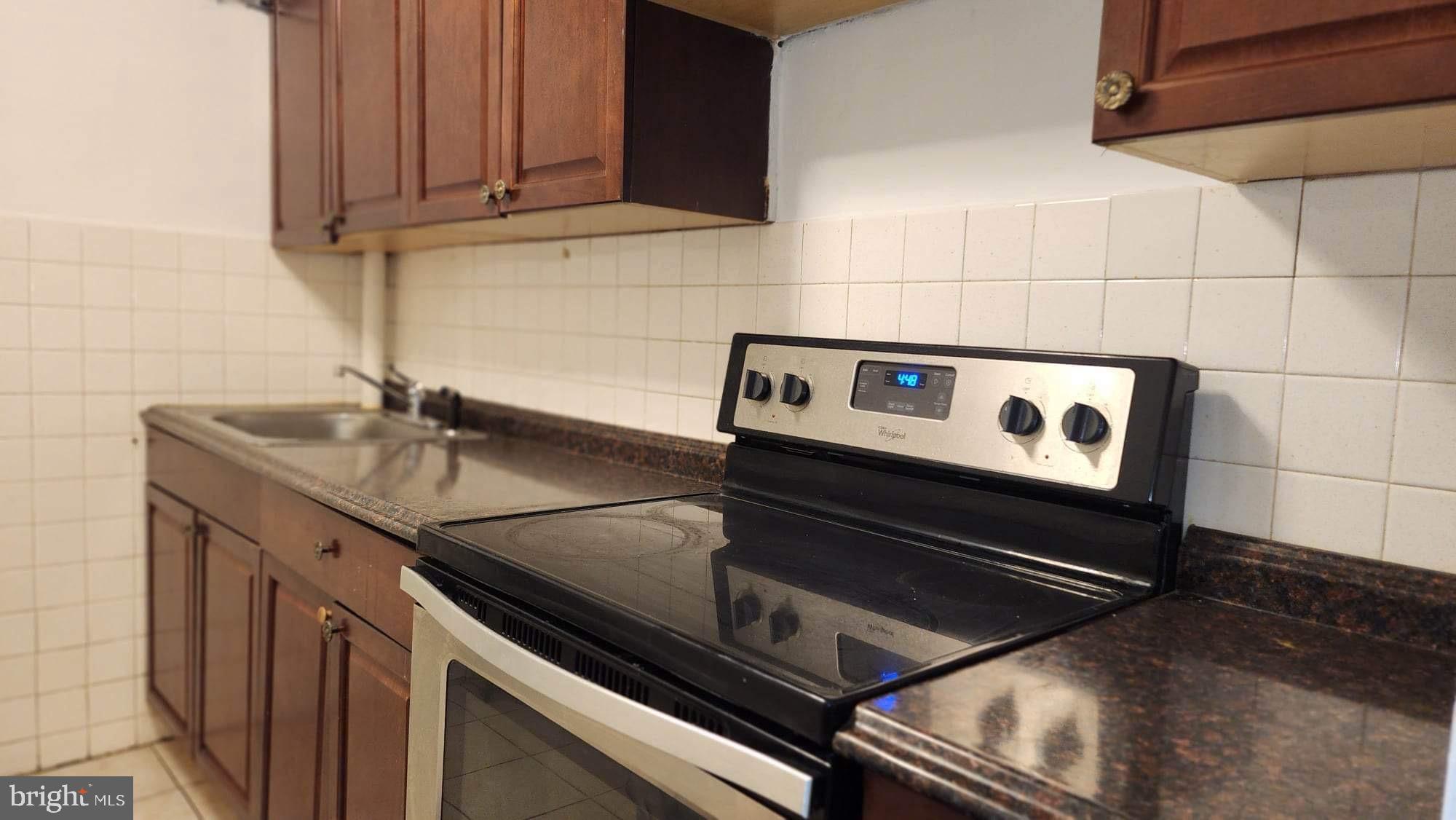 234 Long Lane Upper Darby, PA 19082 - Photo 18 of 29 a kitchen with granite countertop a stove and a sink