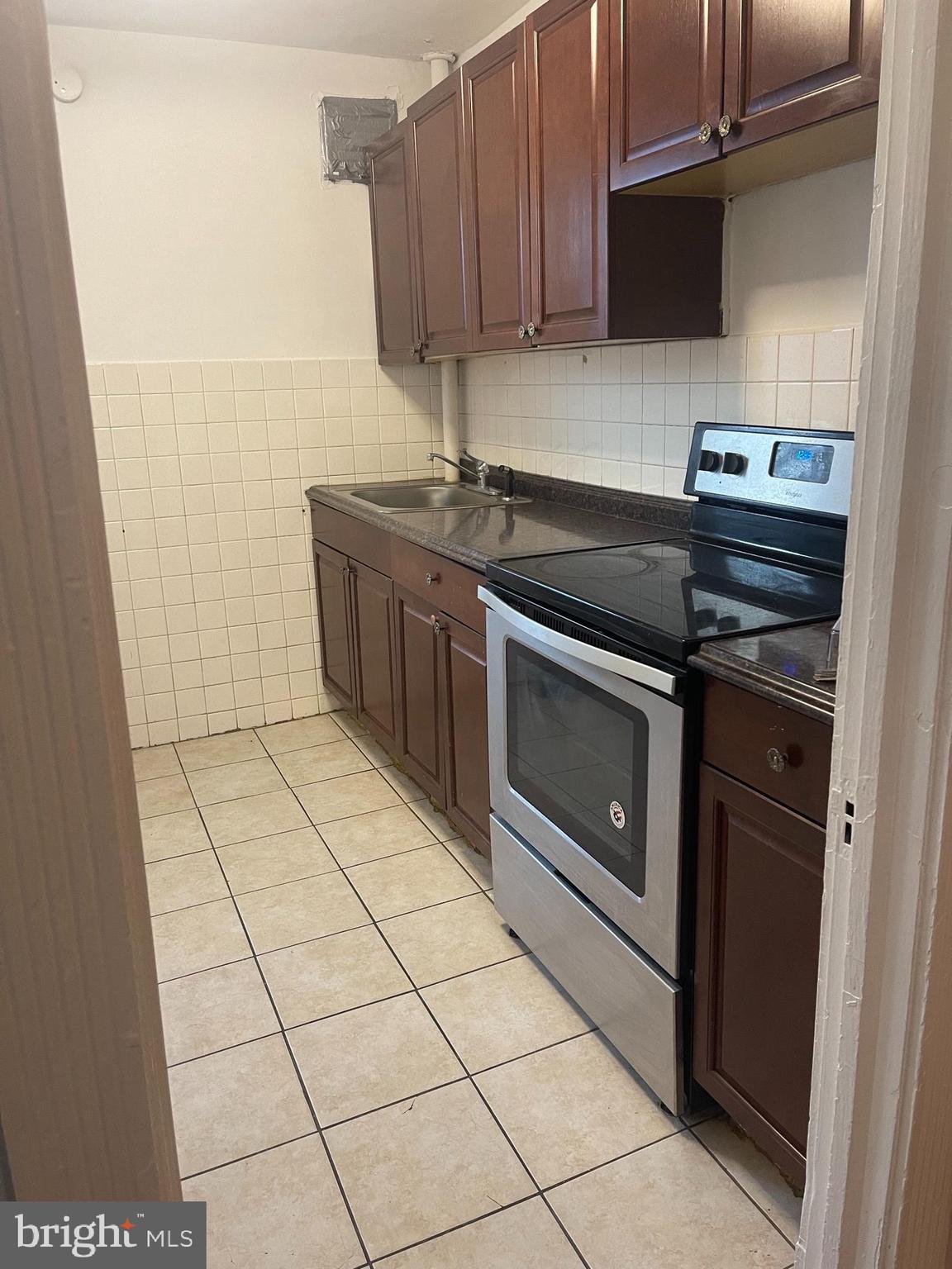 234 Long Lane Upper Darby, PA 19082 - Photo 24 of 29 a kitchen with granite countertop a stove a sink and a microwave
