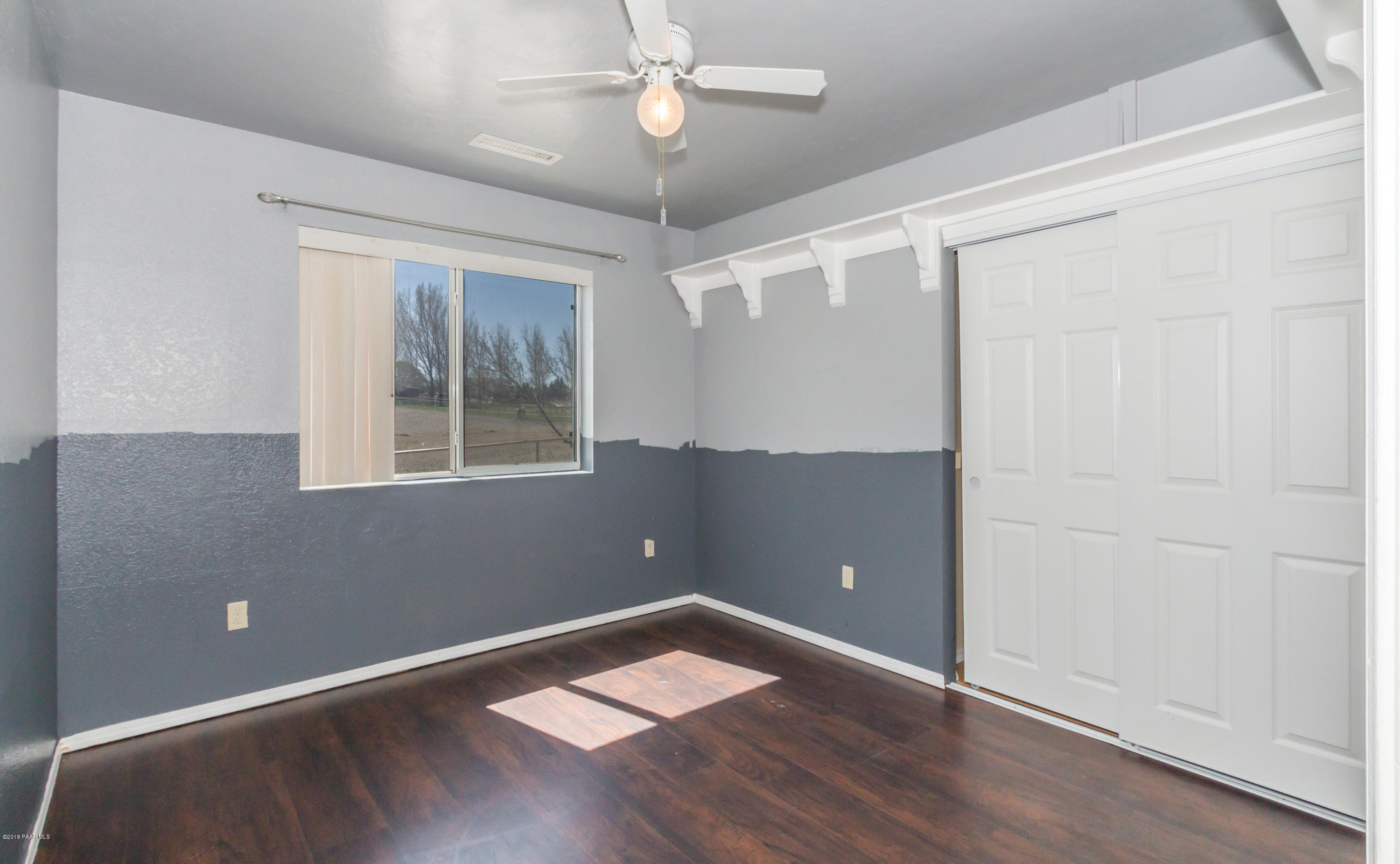 3887 North Reed Road Chino Valley, AZ 86323 - Photo 11 of 18 an empty room with wooden floor and windows