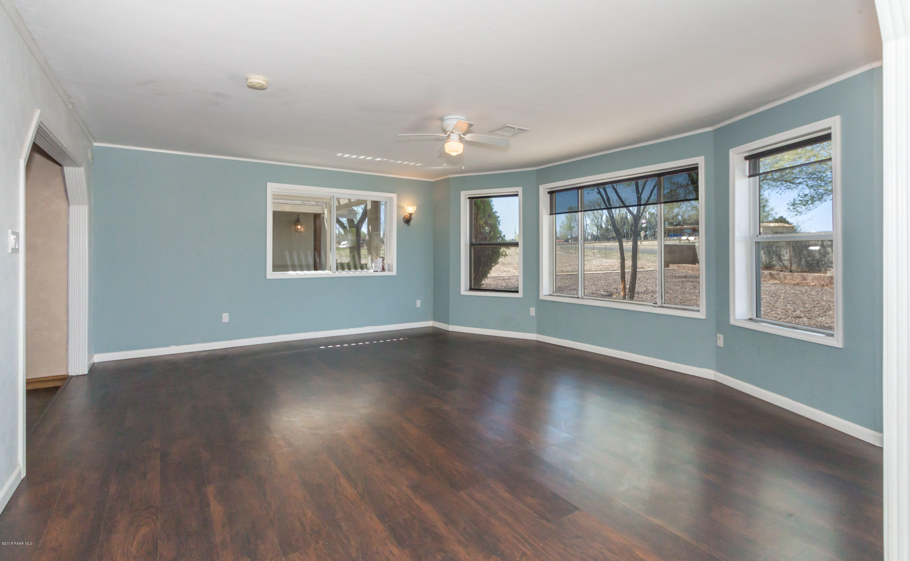 3887 North Reed Road Chino Valley, AZ 86323 - Photo 4 of 18 a view of an empty room with wooden floor and a window