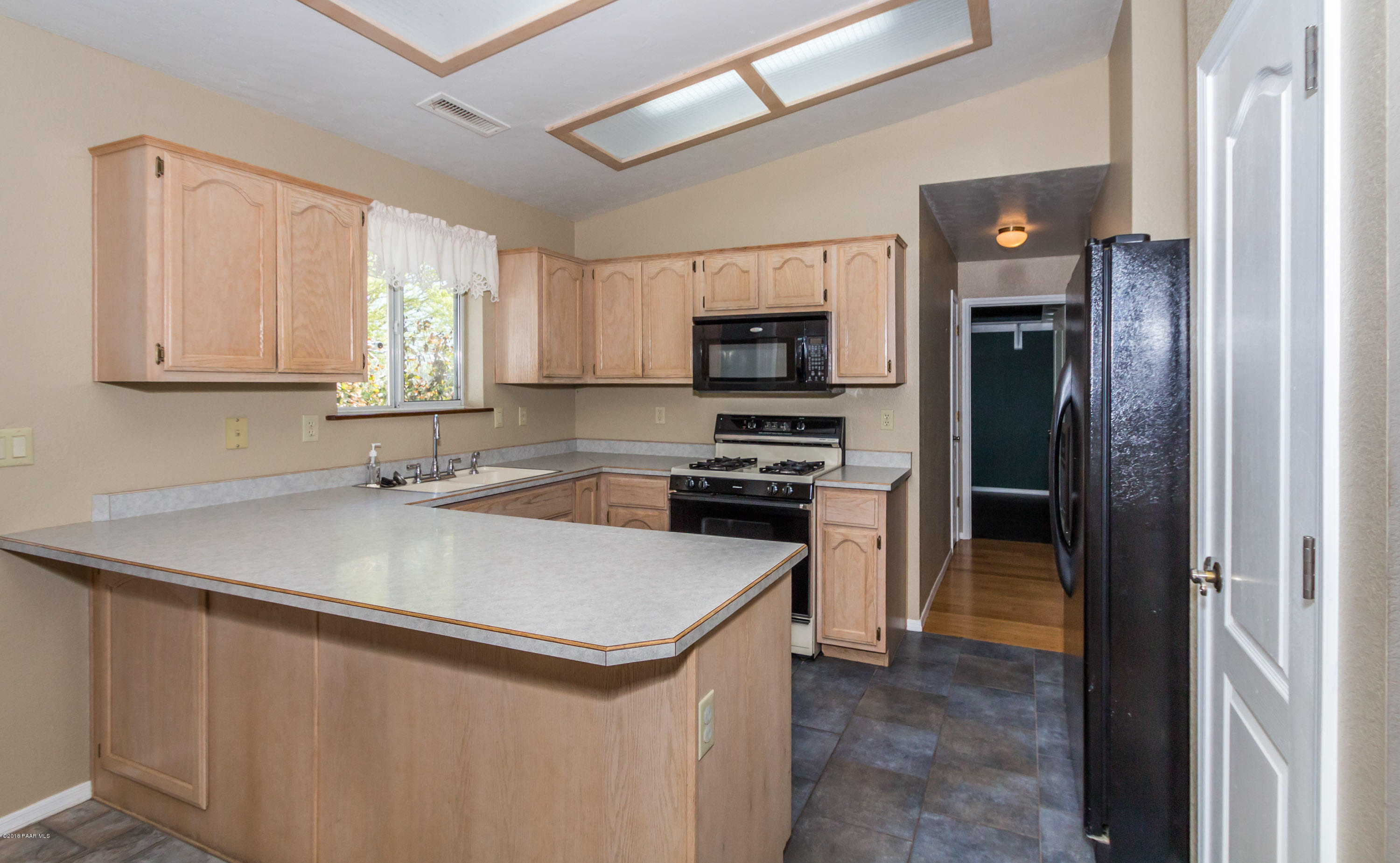 3887 North Reed Road Chino Valley, AZ 86323 - Photo 6 of 18 a kitchen that has a sink a counter top space stainless steel appliances and a window