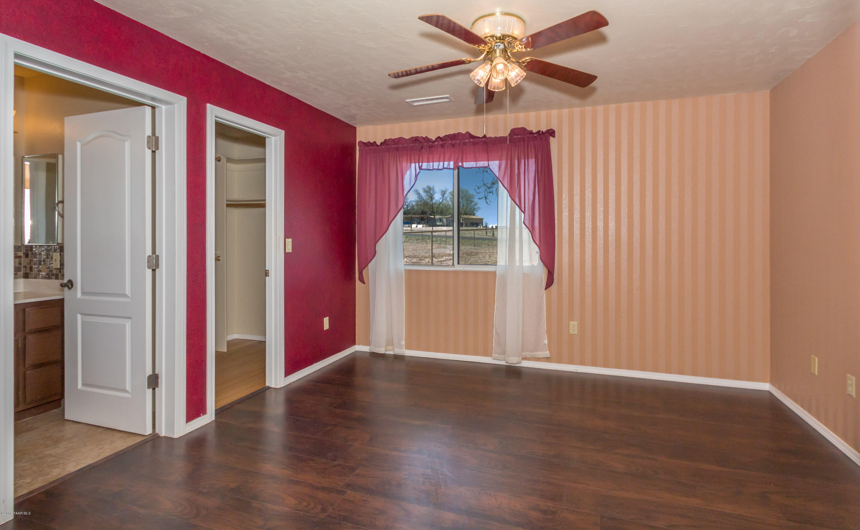 3887 North Reed Road Chino Valley, AZ 86323 - Photo 9 of 18 a view of a livingroom with wooden floor a ceiling fan and a window
