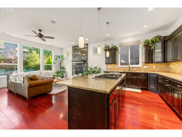 a kitchen with stainless steel appliances granite countertop a sink and a wooden floors