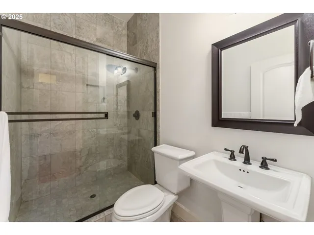 a bathroom with a sink toilet a mirror and shower