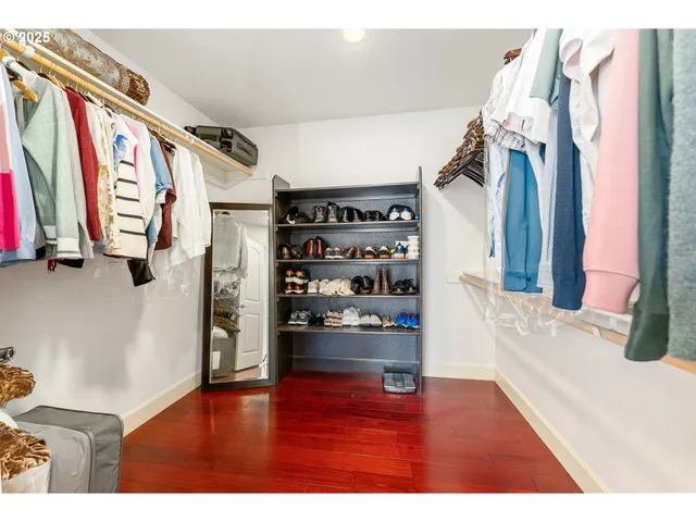 a view of walk in closet with clothes and shoes