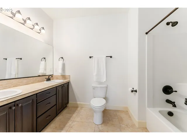 a bathroom with a sink a toilet a mirror and shower