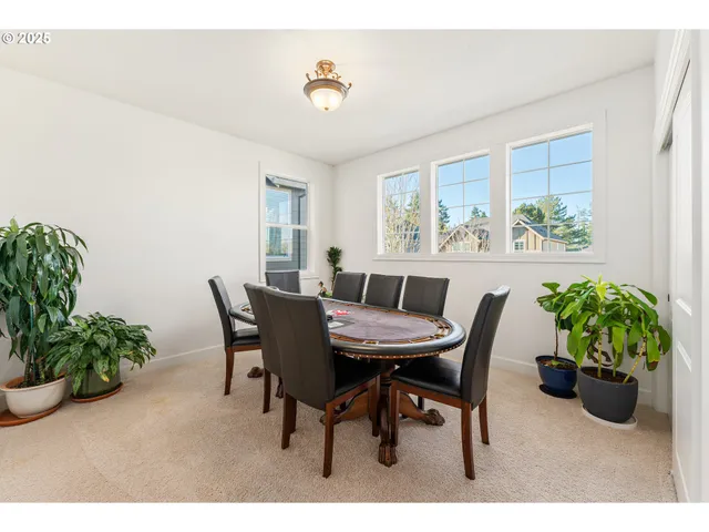 a dining room with furniture potted plants and wooden floor