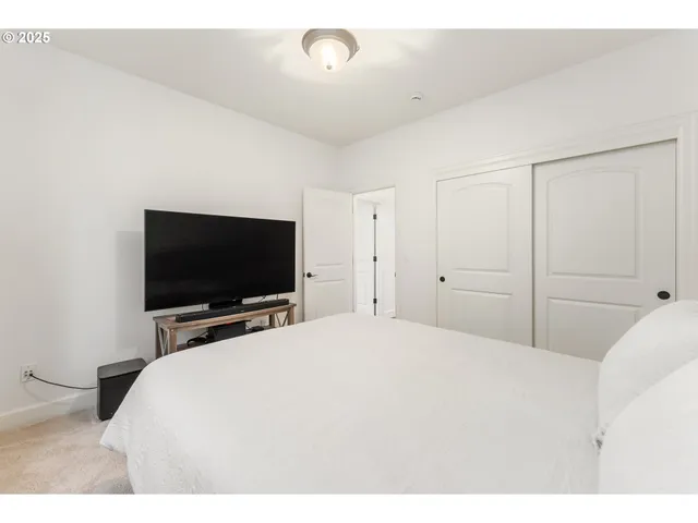 a bedroom with a bed and a flat screen tv