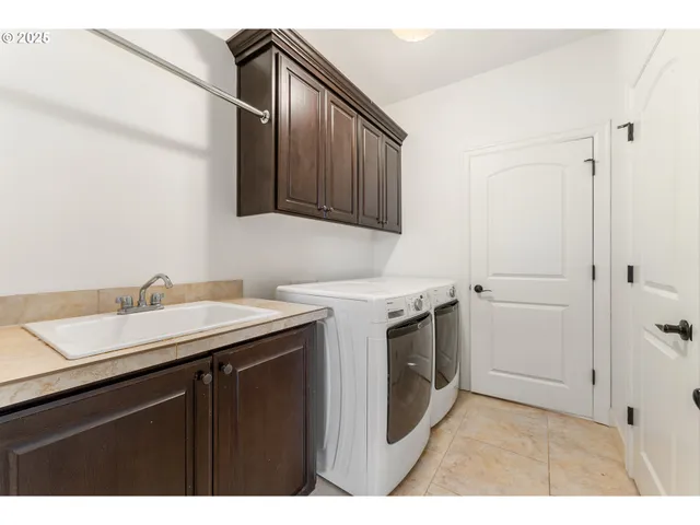 a utility room with sink dryer and washer