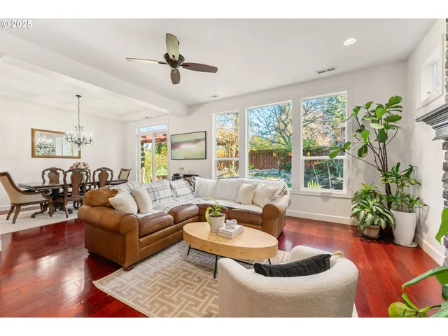 a living room with furniture potted plant and a large window
