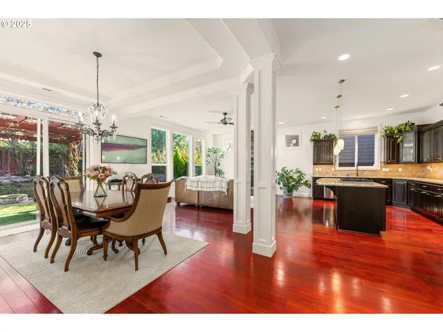 a view of a dining room and livingroom with furniture wooden floor a chandelier
