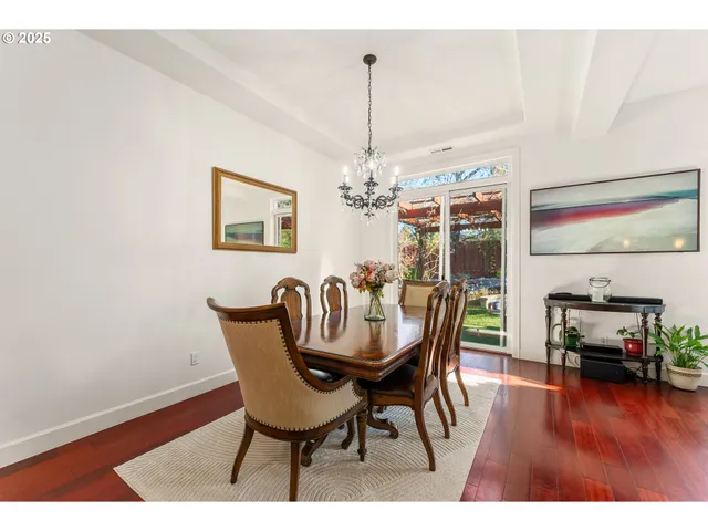 a dining room with furniture wooden floor a rug and a chandelier