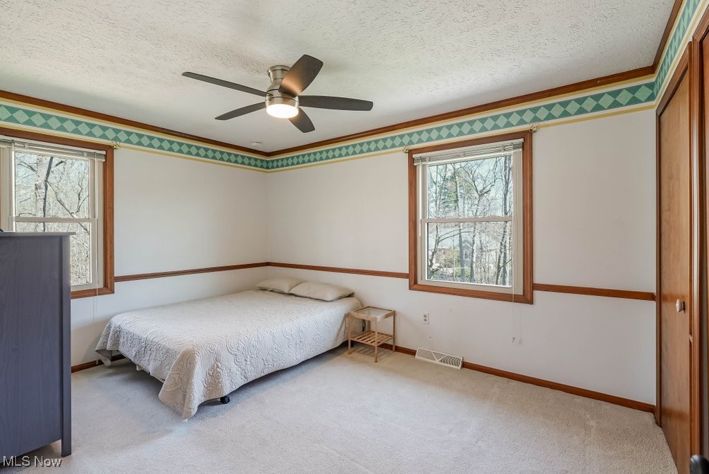 400 Eldridge Road Aurora, OH 44202 - Photo 26 of 42 large carpeted bedroom with ornamental molding, baseboards, visible vents, a ceiling fan.