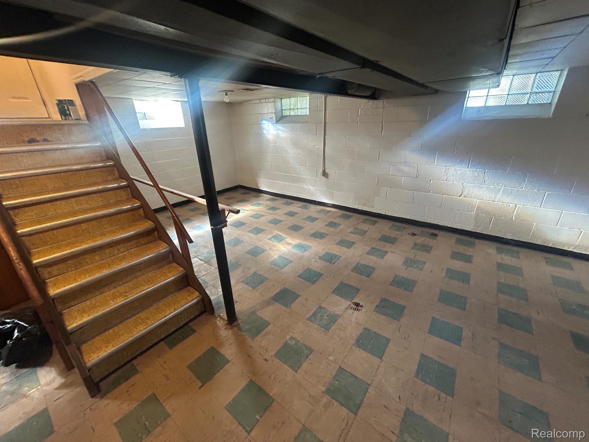21970 Moross Road Grosse Pointe, MI 48236 - Photo 15 of 21 Lower level space featuring block walls, patterned floor tiles, and an exposed overhead beam